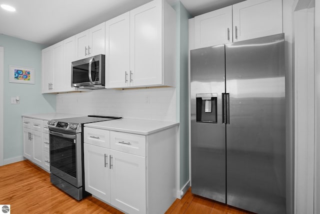 kitchen with stainless steel appliances, light wood-style floors, light countertops, white cabinets, and tasteful backsplash