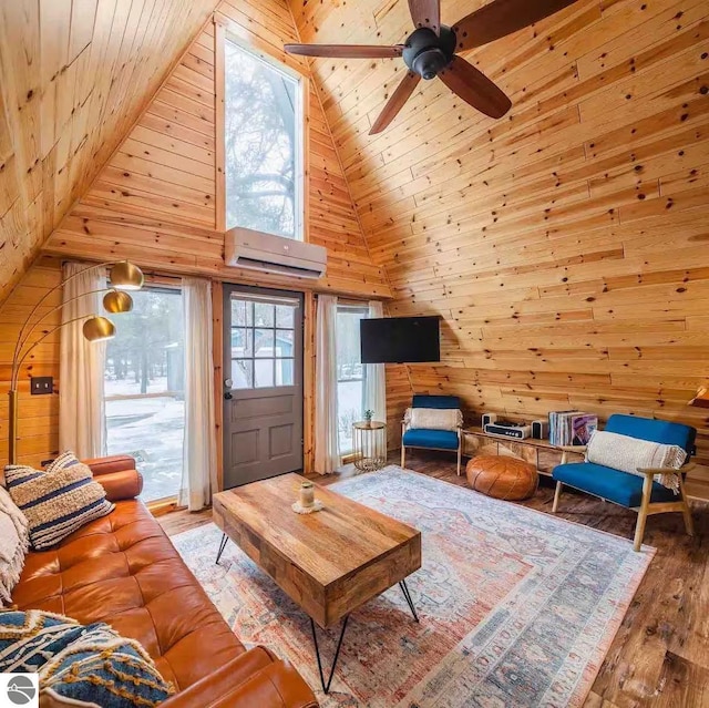 1428 Morel Ln, Grayling, MI 49738 - living area with a wall mounted AC, high vaulted ceiling, wood walls, wood ceiling, and wood finished floors