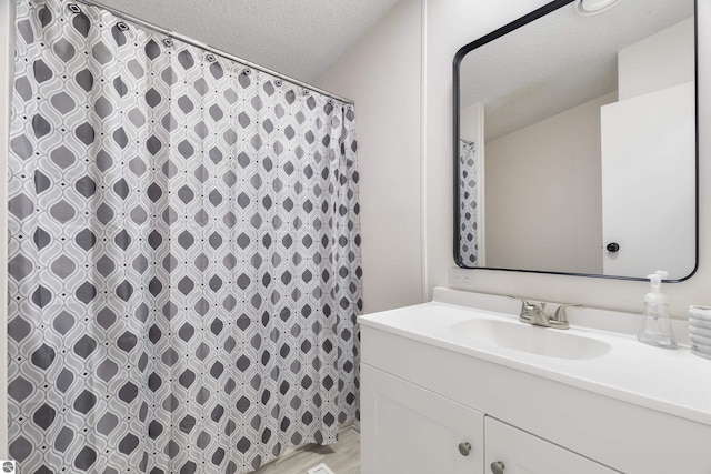 bathroom featuring a textured ceiling, vanity, and a shower with shower curtain