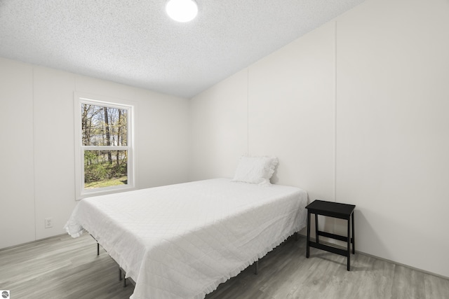 bedroom featuring wood finished floors and a textured ceiling