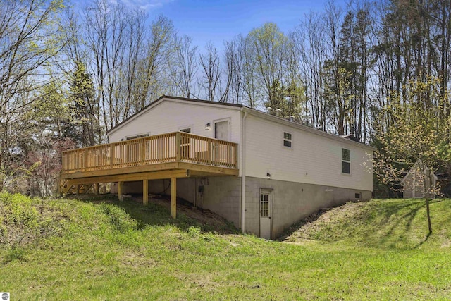 back of property with a deck and a yard
