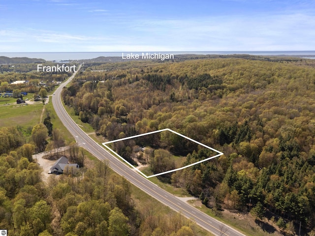 aerial view of property and surrounding area with a heavily wooded area and property boundaries highlighted