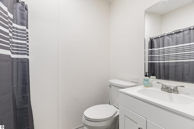full bathroom featuring toilet, vanity, and a shower with shower curtain