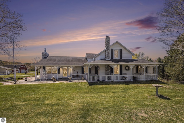 3121 Grace Rd, Frankfort, MI 49635 - farmhouse inspired home with covered porch, a chimney, and a front yard