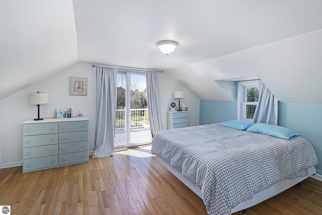 3121 Grace Rd, Frankfort, MI 49635 - bedroom featuring wood finished floors, access to outside, vaulted ceiling, and multiple windows