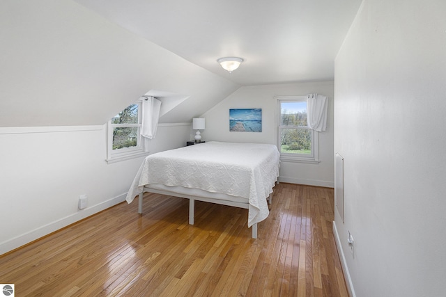 3121 Grace Rd, Frankfort, MI 49635 - bedroom featuring baseboards, light wood-style floors, and vaulted ceiling