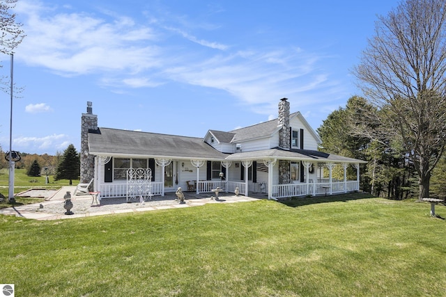 3121 Grace Rd, Frankfort, MI 49635 - back of property with a chimney, a porch, and a lawn