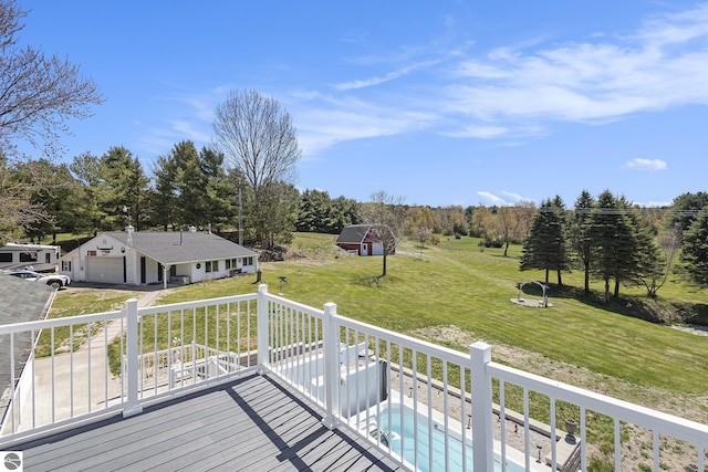 3121 Grace Rd, Frankfort, MI 49635 - deck featuring a garage, a lawn, driveway, and an outdoor structure