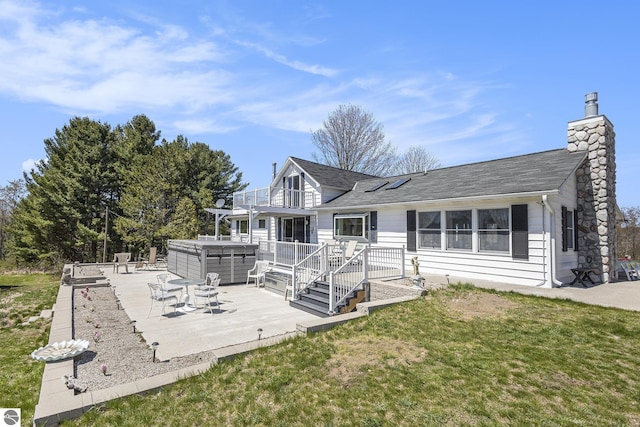 3121 Grace Rd, Frankfort, MI 49635 - back of house with a hot tub, a patio, a chimney, and roof with shingles