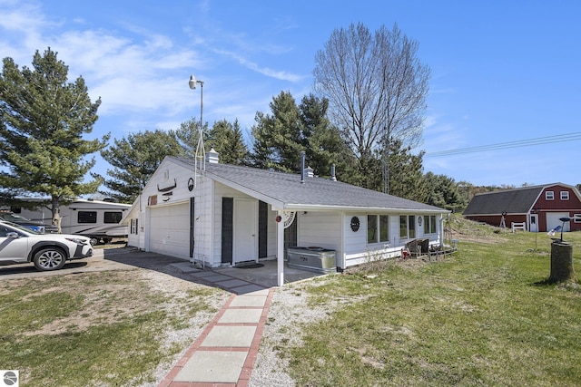 3121 Grace Rd, Frankfort, MI 49635 - view of front of property featuring a garage, a front lawn, a shingled roof, and a chimney