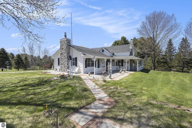 3121 Grace Rd, Frankfort, MI 49635 - rear view of property featuring covered porch, a chimney, and a yard