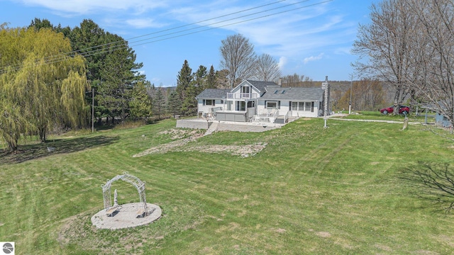 3121 Grace Rd, Frankfort, MI 49635 - back of property with a lawn, a deck, and a view of trees