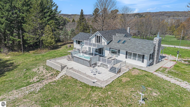 3121 Grace Rd, Frankfort, MI 49635 - back of house with a deck, a balcony, a lawn, a chimney, and a view of trees