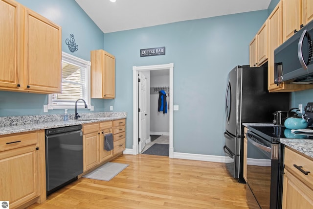 8256 Mapleleaf Dr, Traverse City, MI 49684 - kitchen with appliances with stainless steel finishes, light brown cabinets, a sink, and light wood-style flooring