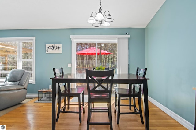 8256 Mapleleaf Dr, Traverse City, MI 49684 - dining area with baseboards, wood finished floors, and a chandelier