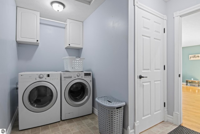 8256 Mapleleaf Dr, Traverse City, MI 49684 - clothes washing area featuring cabinet space, separate washer and dryer, and baseboards