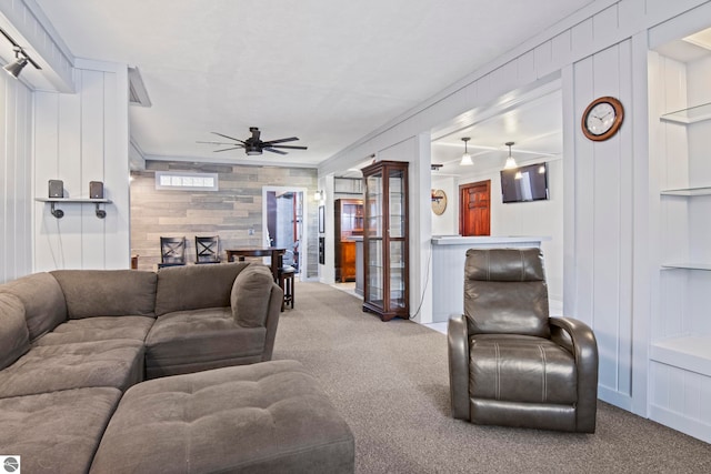 8256 Mapleleaf Dr, Traverse City, MI 49684 - living room with carpet flooring, a ceiling fan, a decorative wall, wooden walls, and built in shelves