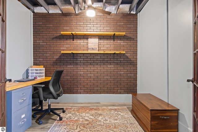 8256 Mapleleaf Dr, Traverse City, MI 49684 - home office with brick wall and wood finished floors