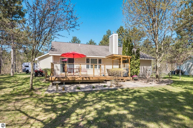 8256 Mapleleaf Dr, Traverse City, MI 49684 - rear view of house with a wooden deck, a yard, and a chimney