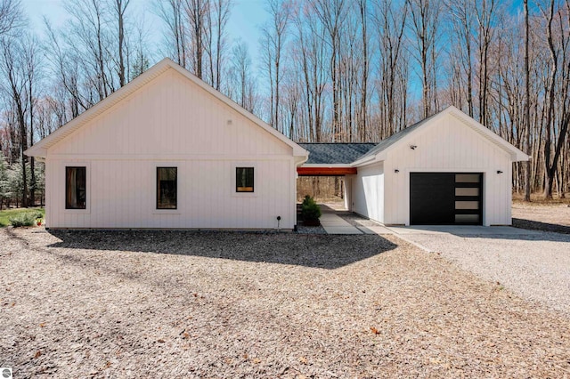 20651 E Trails End Trl, Interlochen, MI 49643 - view of property exterior with an attached garage and gravel driveway