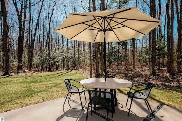 20651 E Trails End Trl, Interlochen, MI 49643 - view of patio featuring outdoor dining space and a wooded view