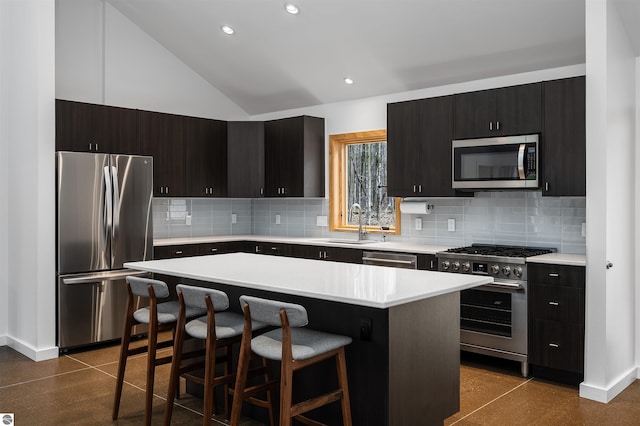 20651 E Trails End Trl, Interlochen, MI 49643 - kitchen with appliances with stainless steel finishes, a sink, a breakfast bar area, light countertops, and lofted ceiling