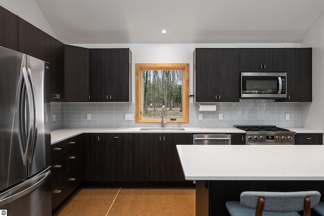 20651 E Trails End Trl, Interlochen, MI 49643 - kitchen with appliances with stainless steel finishes, a sink, decorative backsplash, and dark cabinetry