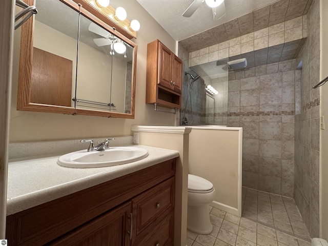 bathroom featuring a ceiling fan, toilet, walk in shower, vanity, and tile patterned floors