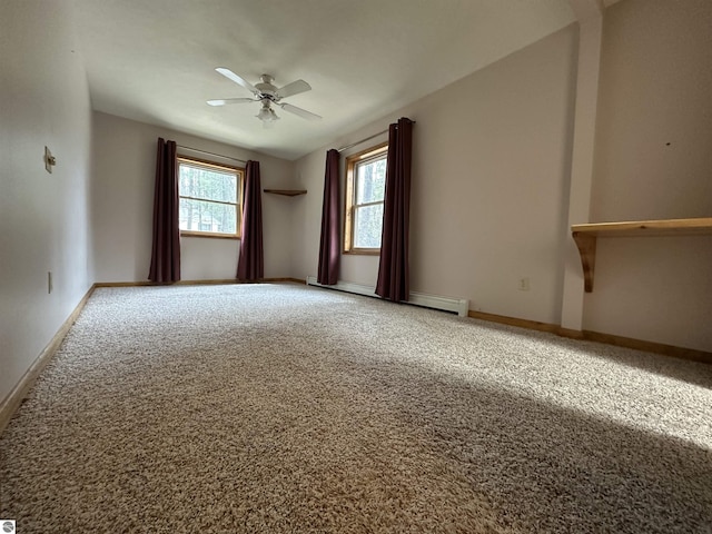 spare room with baseboard heating, carpet floors, ceiling fan, and baseboards