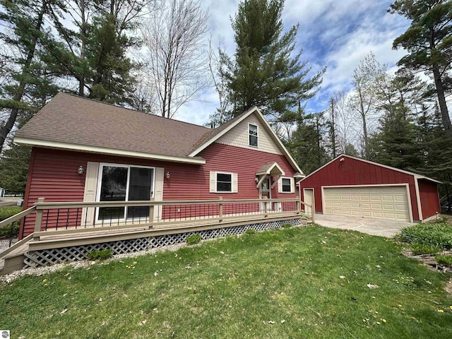 chalet / cabin with an outbuilding, a garage, a deck, a shingled roof, and a front yard
