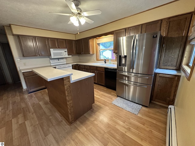 kitchen featuring white appliances, baseboard heating, light wood-type flooring, a textured ceiling, and light countertops
