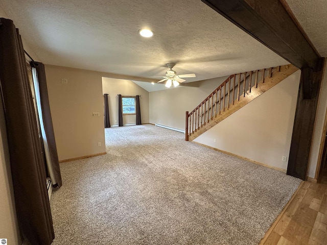 unfurnished living room featuring a baseboard heating unit, ceiling fan, a textured ceiling, baseboards, and carpet flooring