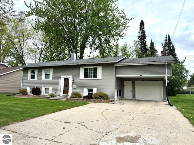 1411 N Dr, Mount Pleasant, MI 48858 - split foyer home with driveway, a front yard, a chimney, and a garage