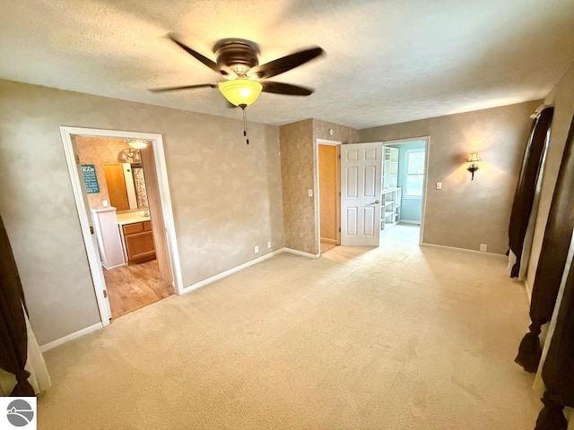 1411 N Dr, Mount Pleasant, MI 48858 - unfurnished bedroom featuring light colored carpet, baseboards, ensuite bathroom, a textured ceiling, and a ceiling fan