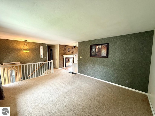 1411 N Dr, Mount Pleasant, MI 48858 - unfurnished room featuring carpet flooring, baseboards, a fireplace, and wallpapered walls