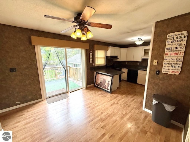 1411 N Dr, Mount Pleasant, MI 48858 - kitchen with white cabinets, light wood-type flooring, a ceiling fan, baseboards, and a peninsula