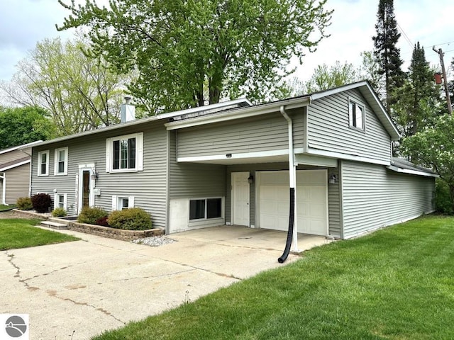1411 N Dr, Mount Pleasant, MI 48858 - split foyer home featuring a front lawn, driveway, a chimney, and an attached garage