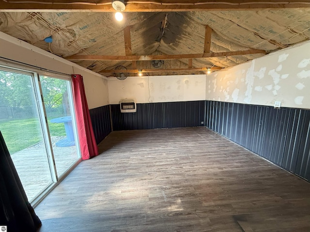 1411 N Dr, Mount Pleasant, MI 48858 - empty room with wood finished floors, vaulted ceiling, and a wainscoted wall