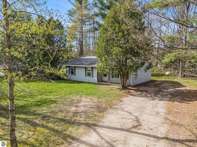 7401 Red Maple Dr, Cadillac, MI 49601 - view of front of home with driveway, a front yard, and a shingled roof