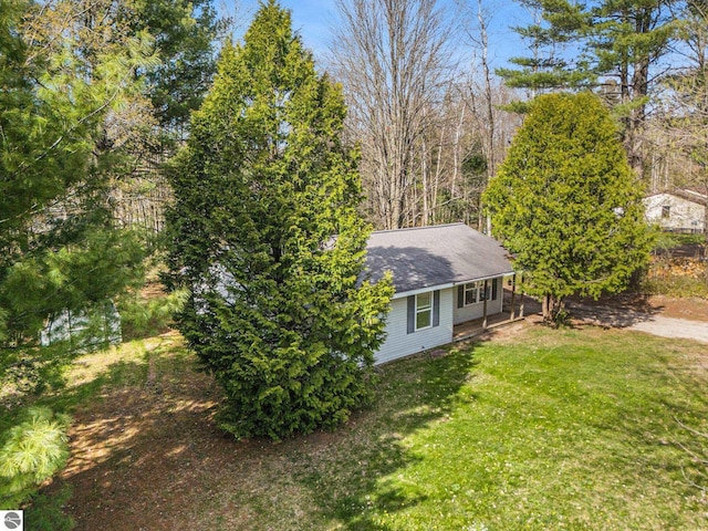7401 Red Maple Dr, Cadillac, MI 49601 - view of side of property featuring a yard and a shingled roof