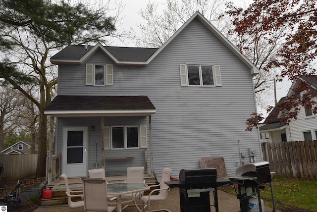back of house with fence and roof with shingles