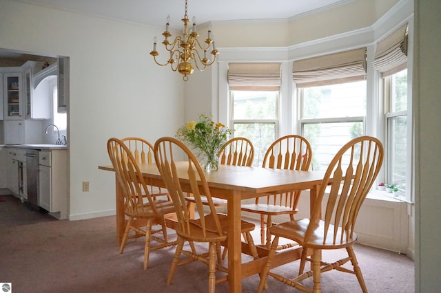 dining area with healthy amount of natural light, a chandelier, light colored carpet, and ornamental molding