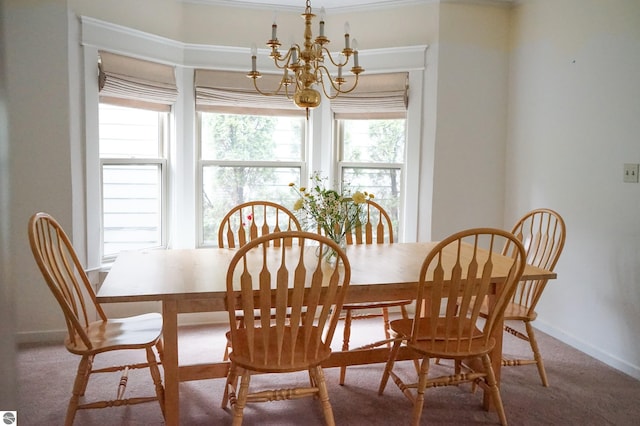 carpeted dining room featuring a chandelier and baseboards