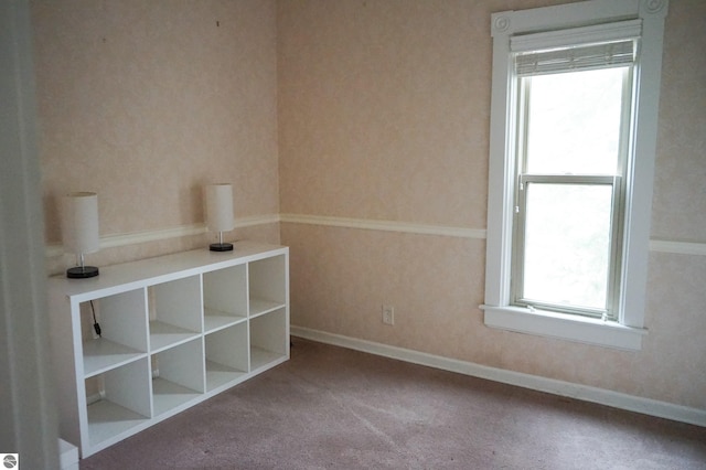 carpeted spare room with baseboards and wallpapered walls