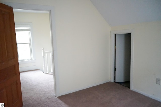 additional living space featuring carpet, vaulted ceiling, and baseboards