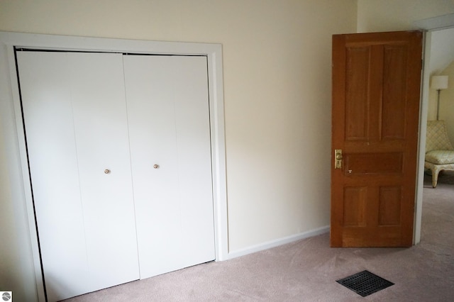 unfurnished bedroom featuring carpet floors, a closet, and baseboards