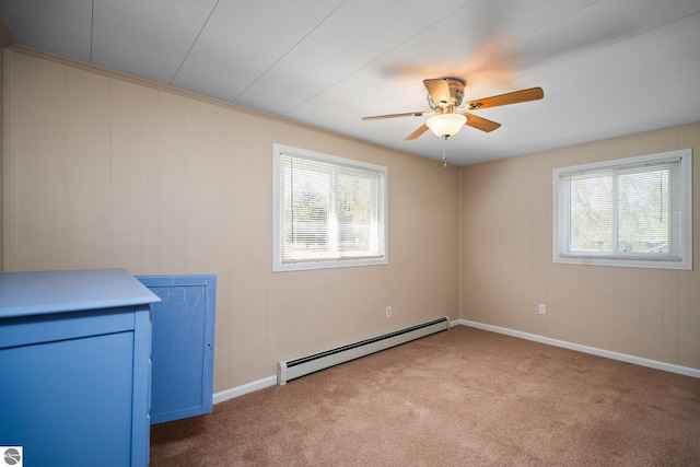 9869 E Cherry Bend Rd, Traverse City, MI 49684 - unfurnished room featuring baseboard heating, plenty of natural light, ceiling fan, and carpet
