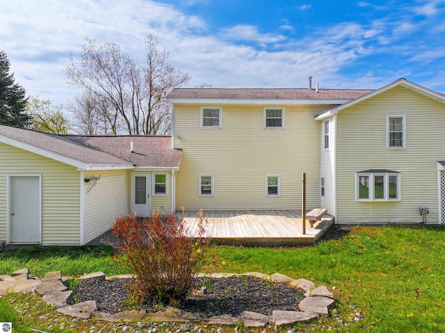 8377 Zosel St, Onekama, MI 49675 - rear view of house featuring a lawn and a wooden deck