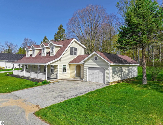 8377 Zosel St, Onekama, MI 49675 - view of front facade with an attached garage, covered porch, driveway, and a front yard