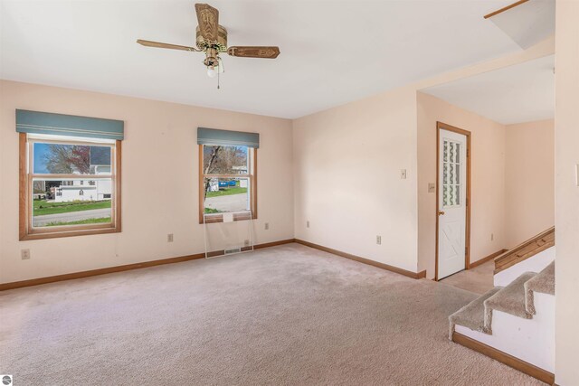 8377 Zosel St, Onekama, MI 49675 - empty room featuring carpet floors, baseboards, a ceiling fan, and stairs